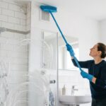 Frau putzt Bad mit plastikbesen