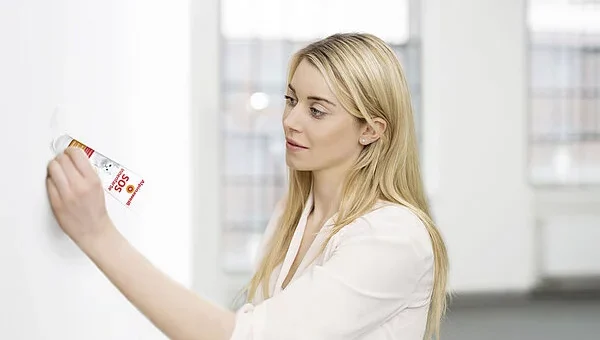 frau repariert schaden an wand